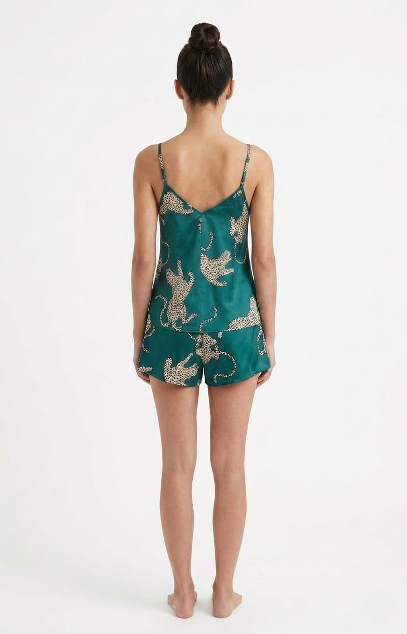 Woman wearing a teal satin slip with animal print on a white background