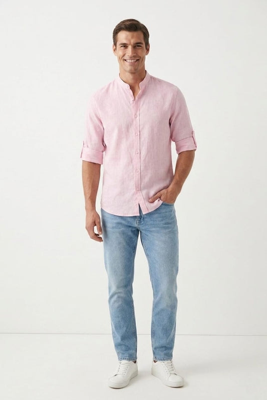 Man wearing a pink shirt and light blue jeans on a white background